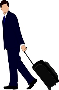 handsome young businessman in a suit and tie on a business trip pulling his suitcase behind him